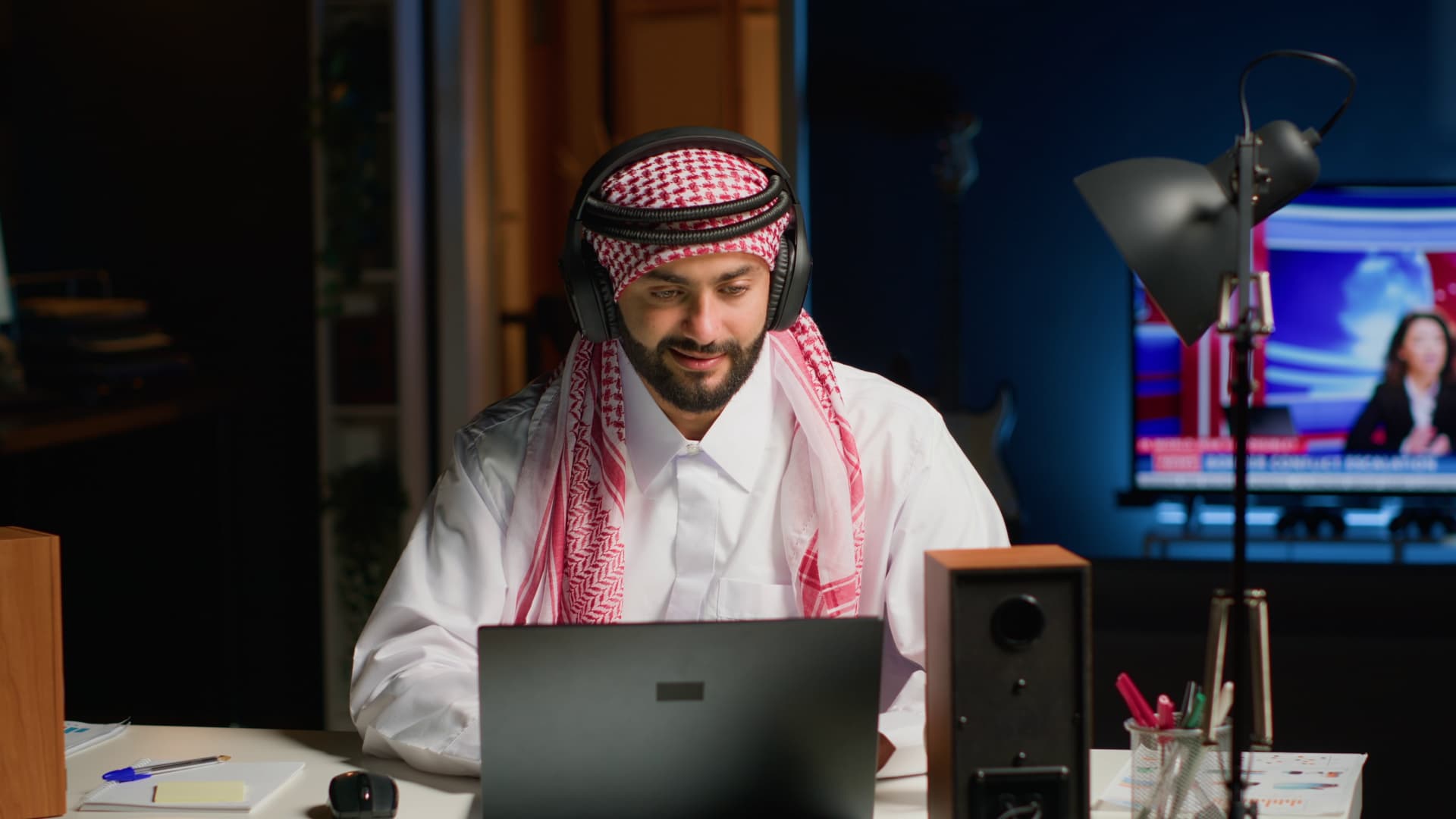 Online teacher taking a live class from home on a laptop with a headset